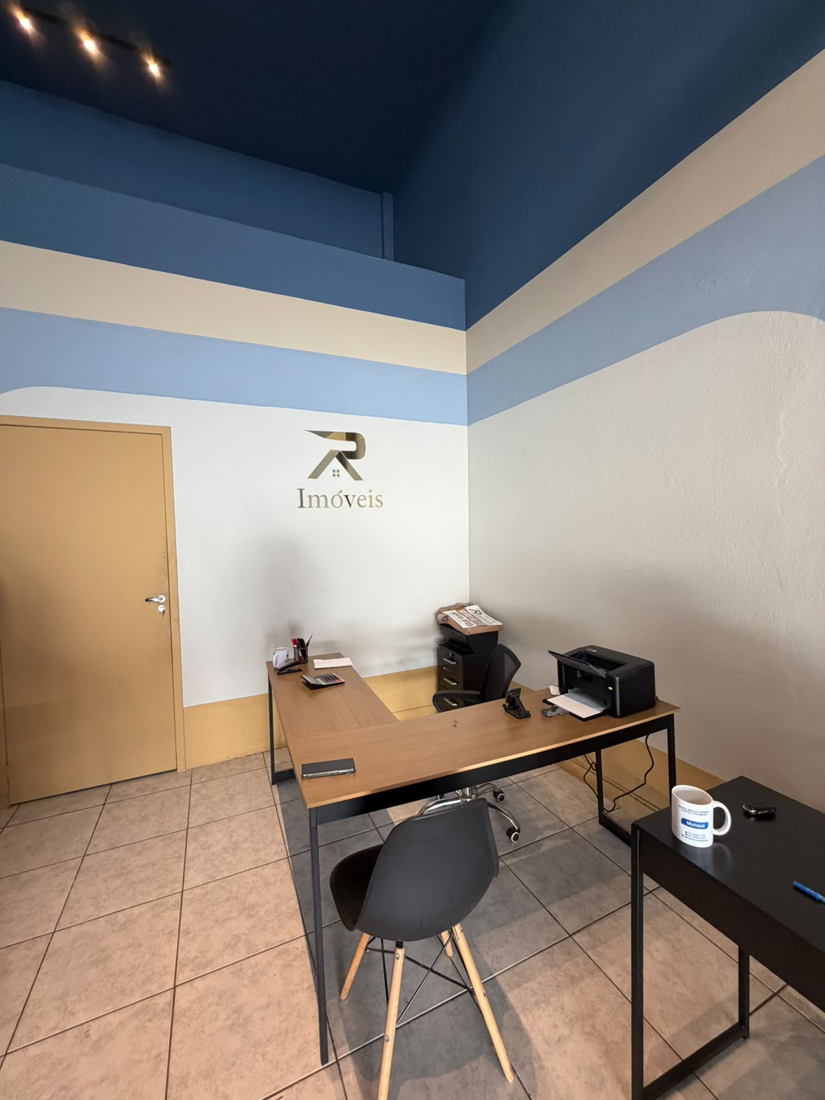 Sala da AR Imóveis com a marca na parede